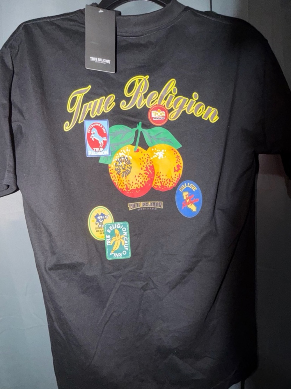 True Religion Black Tee with Yellow Logo and Orange Fruit Graphic